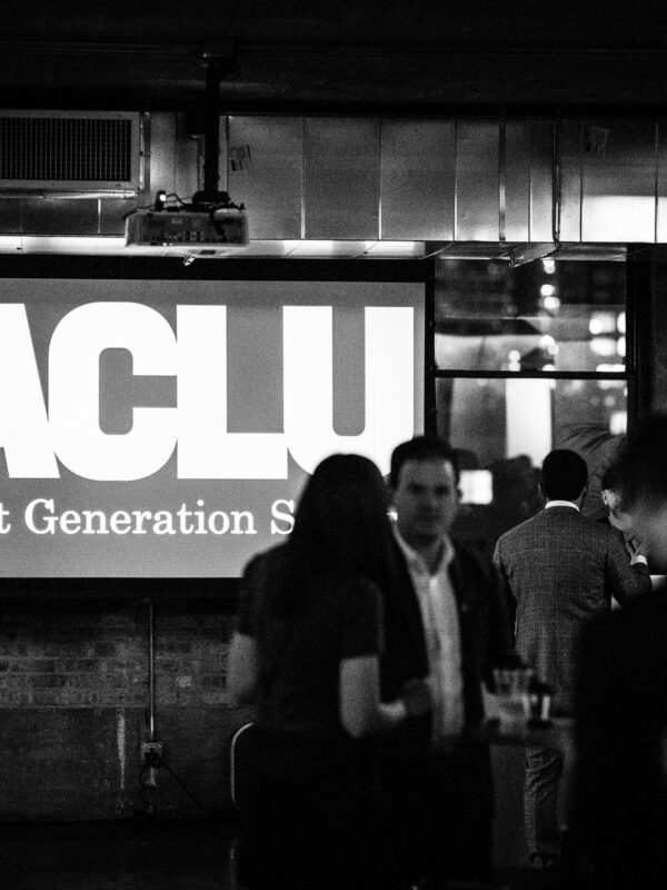 black and white image of NG Society logo on a large screen at an event