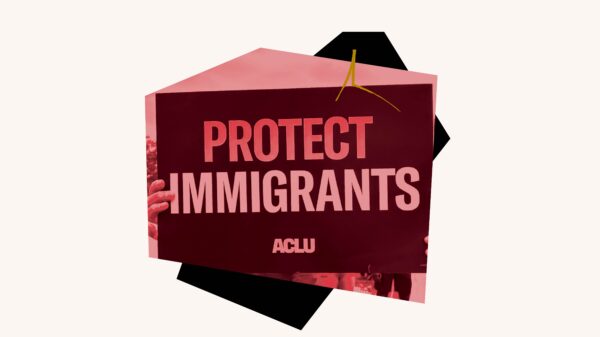 Red filtered image of "Protect Immigrants" sign