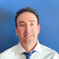 Headshot of Kevin in front of a blue wall.