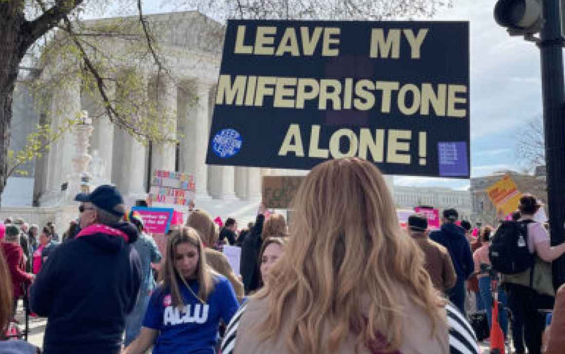 Person holding a "Leave my Mifepristone Alone" sign in front of the Supreme Court