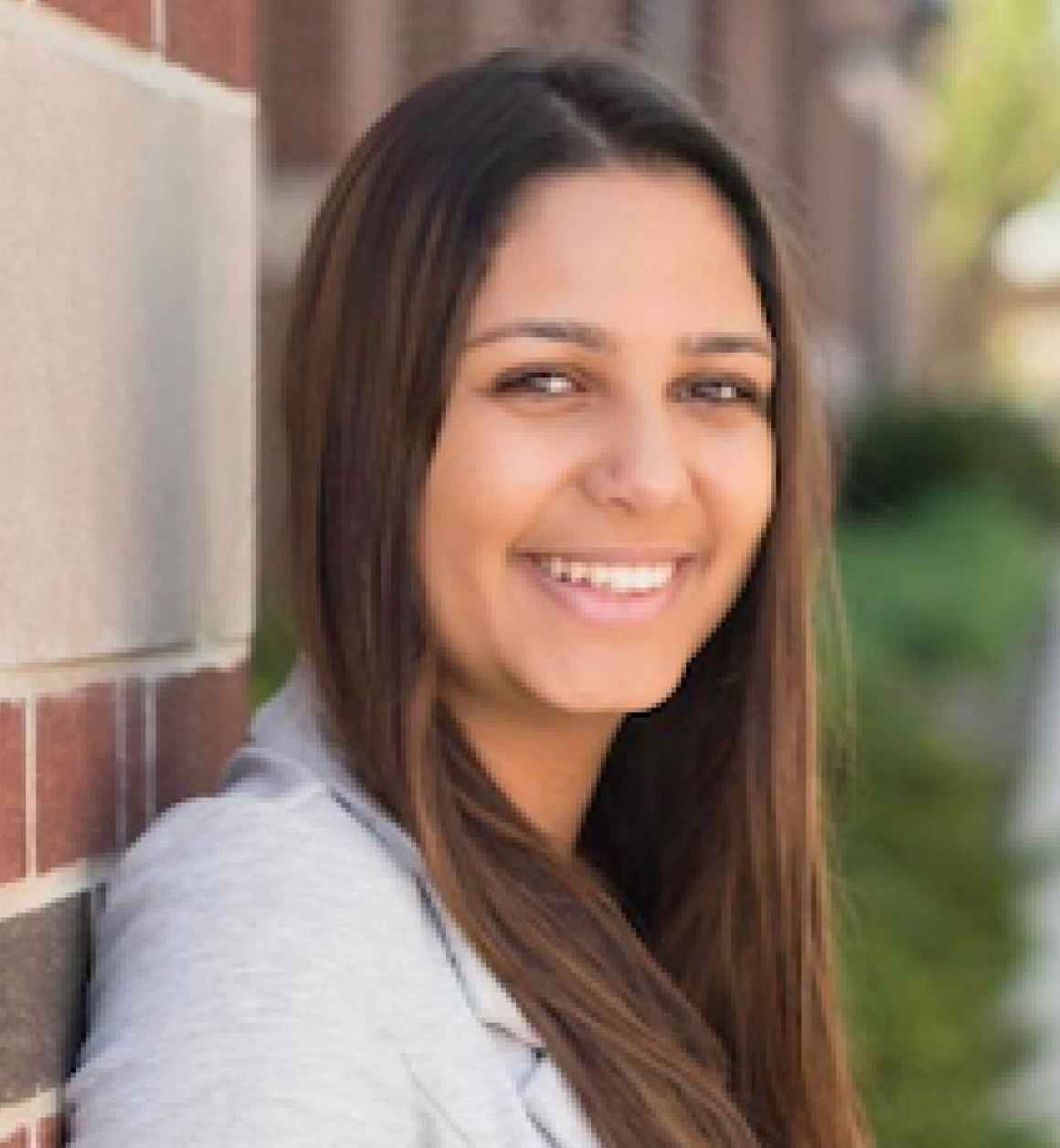 Headshot of Leyda standing in front of a brick wall